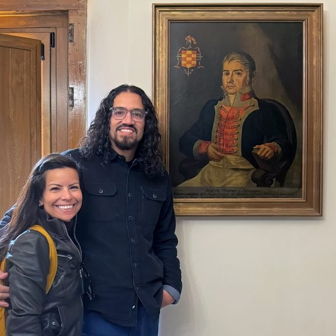 The author and his wife beside a portrait of Jorge de Cisneros y Duran Sotomayor in Seville